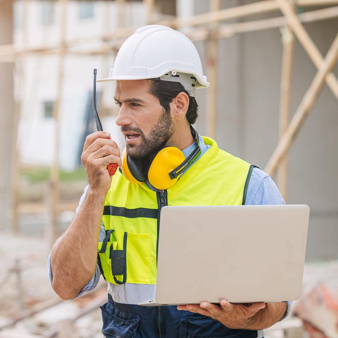 worker foreman engineer builder working using radio command in home construction site safety check.